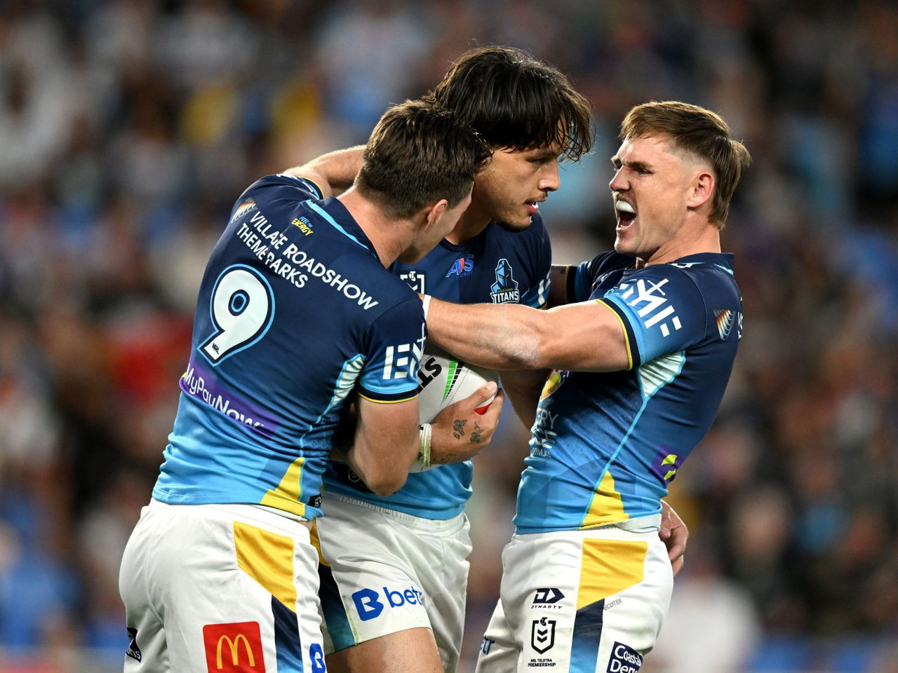 NRL Gold Coast Titans three players celebrating on field